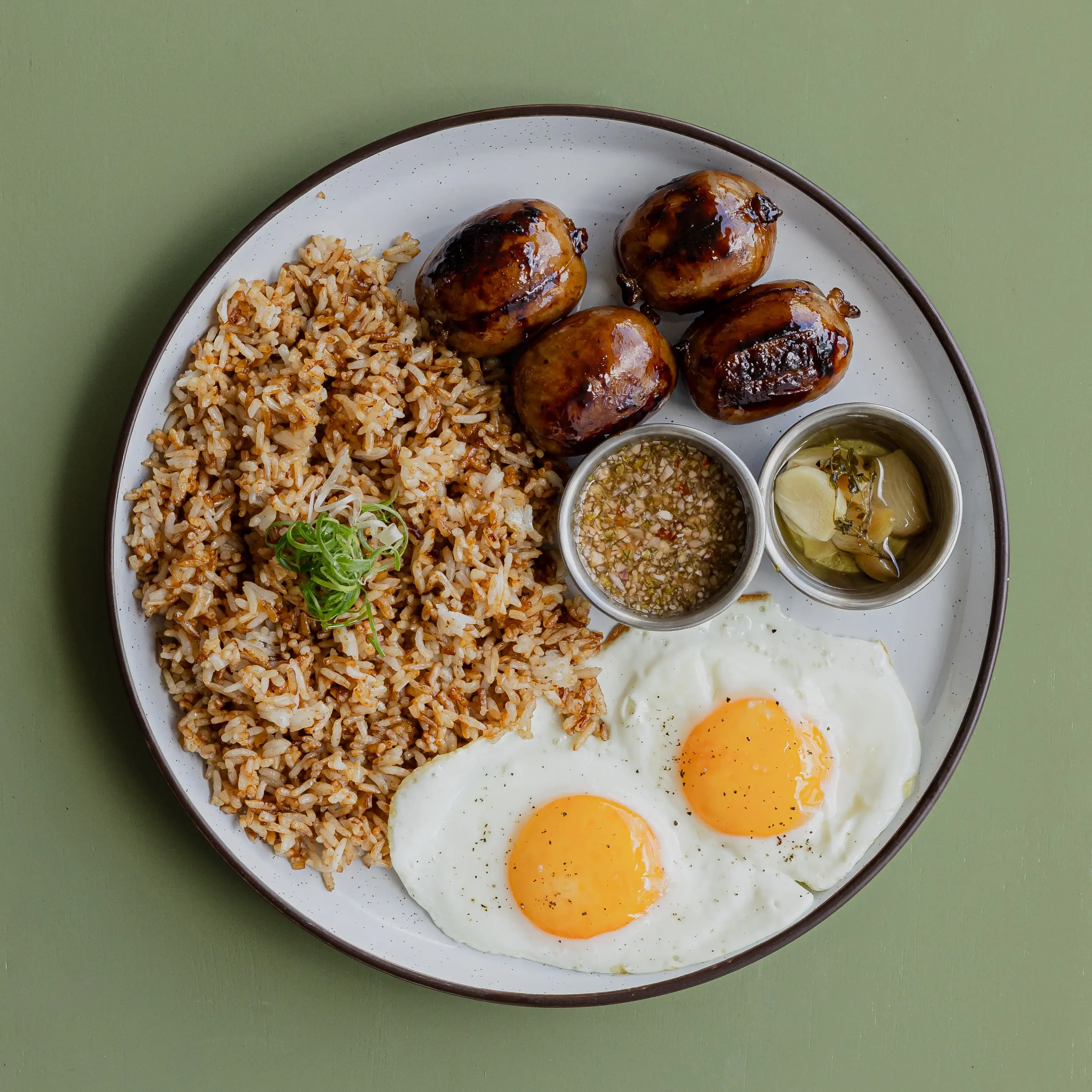 Grilled chorizo, two sunny side up eggs, chorizo fried rice, pickled slaw